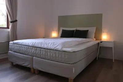 a bedroom with a large bed with two lamps on it at Valldal Gjestgiveri in Valldal