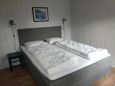 a bed with white sheets and pillows on it at Hogstul Hytter - Knatten - 3 Bedroom Cottage in Tuddal