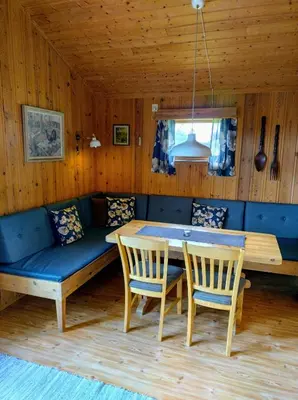 a dining room with a bench and a table and chairs at Hogstul Hytter - Apartment South in Tuddal