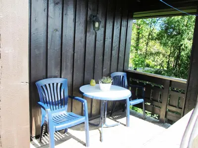 two blue chairs and a table on a patio at Hogstul Hytter - Apartment South in Tuddal