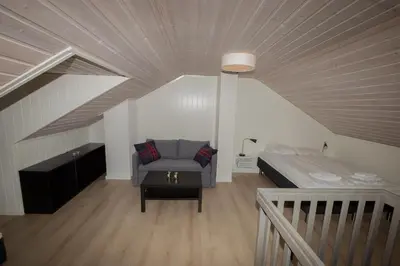 a room with a bed and a couch in a attic at Nordseter Apartments in Lillehammer