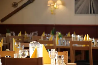 a restaurant with tables and chairs with glasses on them at Nordseter Apartments in Lillehammer