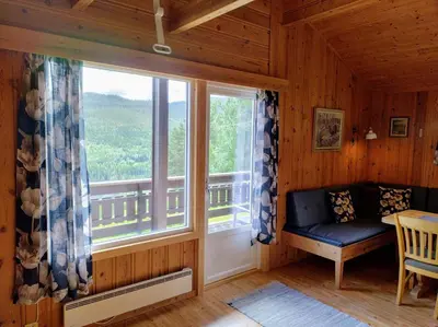 a room with a window with a bench and a table at Hogstul Hytter - Apartment North in Tuddal