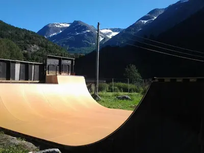 a wooden skateboard ramp with mountains in the background at Folven Adventure Camp in Hjelle