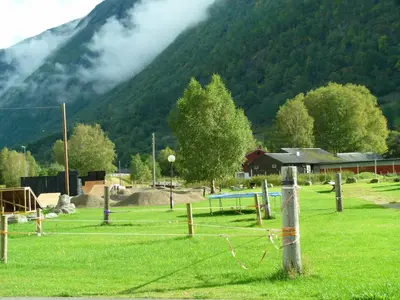 a field of grass with a mountain in the background at Folven Adventure Camp in Hjelle