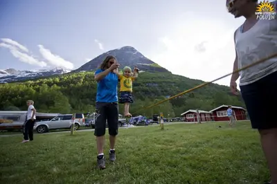 a woman and a child flying a kite in a field at Folven Adventure Camp in Hjelle