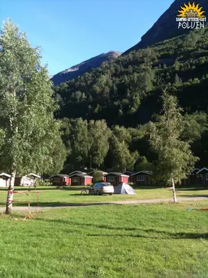 a field with a tent and a mountain in the background at Folven Adventure Camp in Hjelle
