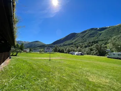 a view of a field with mountains in the background at Vistdal Camping in Myklebostad