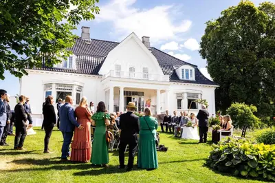 a group of people standing in front of a house at Thorbjørnrud Hotell in Jevnaker