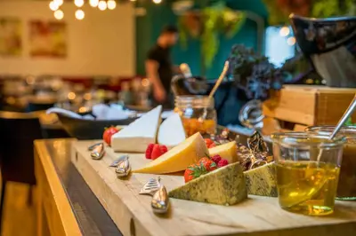a table topped with cheese and fruit on a table at Thorbjørnrud Hotell in Jevnaker