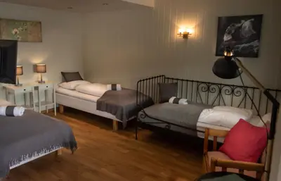 a room with two beds and a tv in it at Storestølen Fjellhotell in Hovet