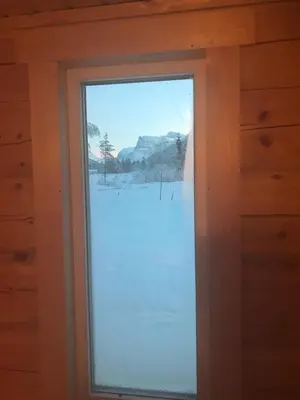 a window in a cabin with a view of the snow at Camp Dronningkrona in Ålvundeid