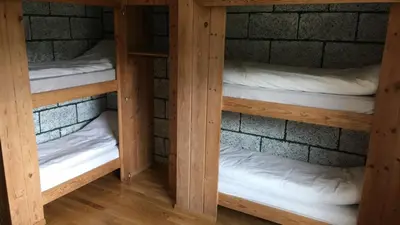 two wooden bunk beds in a brick room at Voss Lodge Rongastovo in Vossevangen