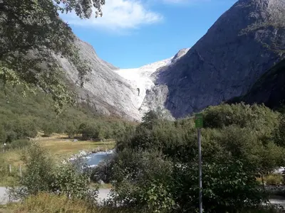a snow covered mountain with a river in a valley at Naustvoll in Olden