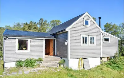 a small gray house on a hill with trees at Stunning Home In Haulandshella in Tveitevåg