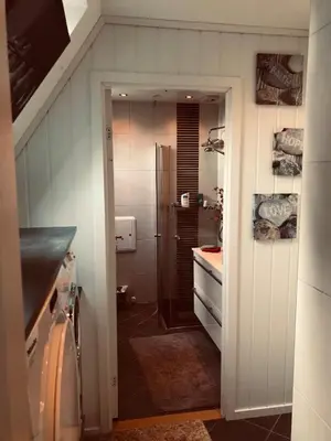 a kitchen with a sink and a refrigerator at Ålesund downtown loft room with shared bathroom in Ålesund