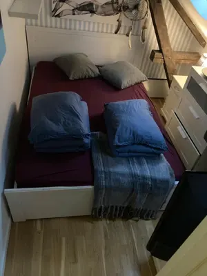 a bed with two pillows on it in a room at Ålesund downtown loft room with shared bathroom in Ålesund