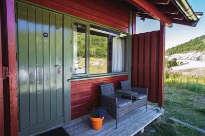 a porch of a house with two chairs and a door at Maristova apartment 110 in Filefjell