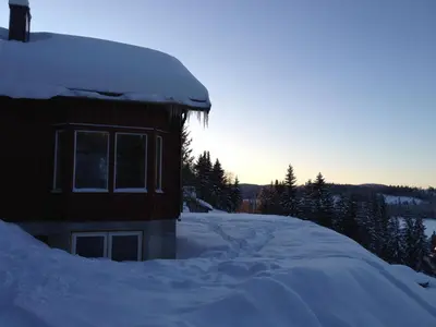 a building covered in snow with the sun in the background at Totakbu in Rauland