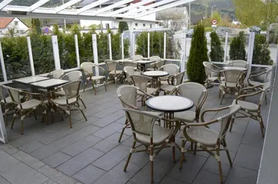 a row of tables and chairs on a patio at Sentrum Hotel in Nordfjordeid