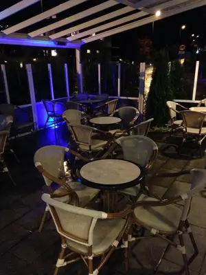 a group of tables and chairs on a patio at night at Sentrum Hotel in Nordfjordeid
