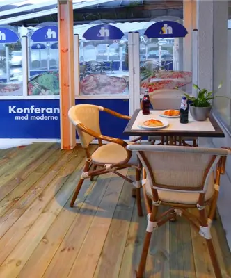 a table and chairs sitting in front of a restaurant at Sentrum Hotel in Nordfjordeid