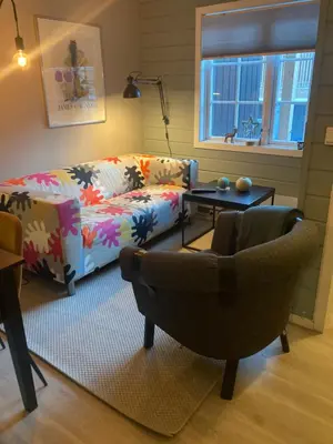a living room with a couch and a chair at Oppdal Alpintun in Oppdal