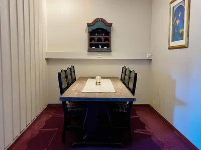 a dining room table with chairs and a clock on the wall at Fanitullen Apartments in Hemsedal