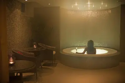a woman sitting in a bath tub in a room at Hovde Gård in Brekstad