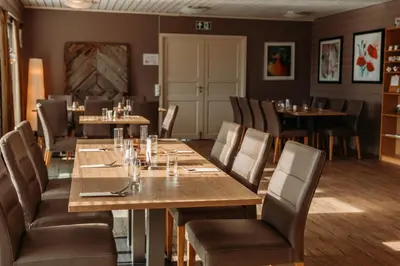 a dining room with wooden tables and chairs at Solund Leileghetshotell in Hardbakke