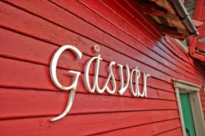 a sign on the side of a red building at Solund Leileghetshotell in Hardbakke