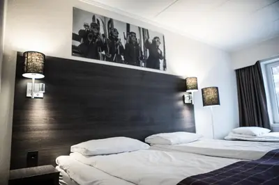 two beds in a hotel room with a headboard at Geilo Hotel in Geilo