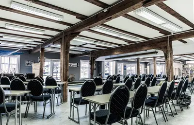 a row of tables and chairs in a room with windows at Knutholmen in Kalvåg