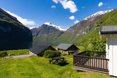 a cabin with a view of a lake and mountains at Geirangerfjorden Feriesenter in Geiranger
