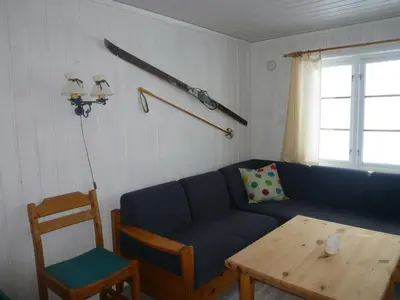 a living room with a blue couch and a table at Skei Apartments in Svingvoll