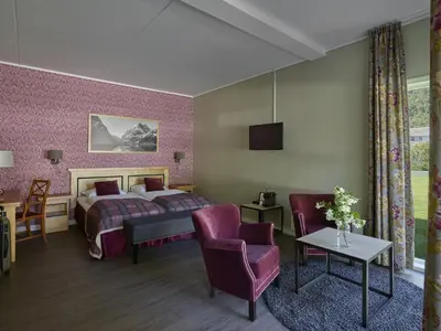 a hotel room with a bed and a table and chairs at Fretheim Hotel in Flåm