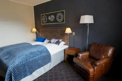 a hotel room with a bed and a chair at Fretheim Hotel in Flåm