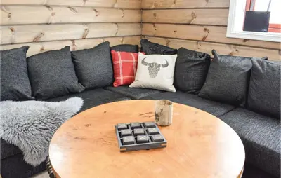 a living room with a couch with a table at Cozy Home In Sjusjøen With Kitchen in Sjusjøen