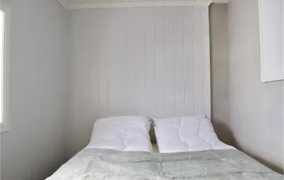 a bed with white sheets in a white room at Cozy Home In Sjusjøen With Kitchen in Sjusjøen