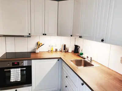 a kitchen with white cabinets and a sink at Fjellhagen in Bjørkheim