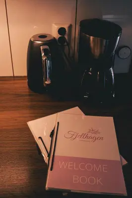 a welcome book sitting on a table next to a blender at Fjellhagen in Bjørkheim