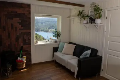a living room with a couch and a window at Fjellhagen in Bjørkheim