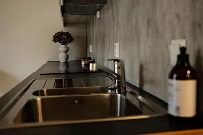 a kitchen sink with a bottle of wine next to it at Blue House Odda in Odda