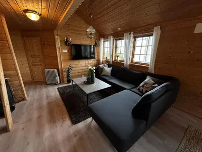 a living room with a couch and a table at Faleide Panorama Private Fjord View Cabin with Large Terrace in Stryn