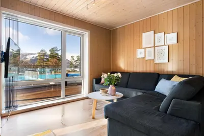 a living room with a couch and a large window at Mikkelparken Ferietun in Kinsarvik