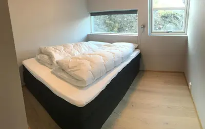 a bed with a blanket on it in a room with a window at Haukelifjell Skisenter in Vågsli