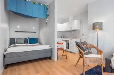 a small bedroom with a bed and a kitchen at NG Apartments in Bergen