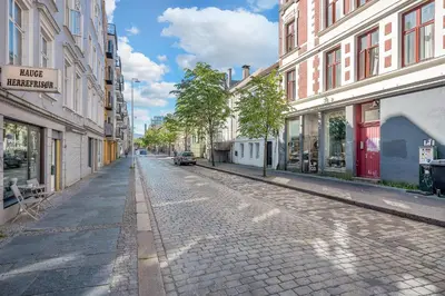 an empty street in a city with buildings at NG Apartments in Bergen