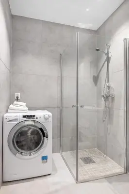 a washing machine in a bathroom with a shower at NG Apartments in Bergen
