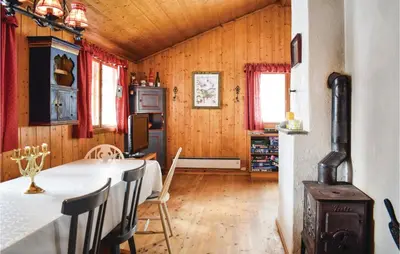 a dining room with a table and chairs and wooden walls at 5 Bedroom Stunning Home In Noresund in Noresund